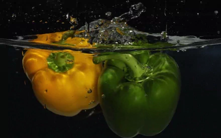 HD PC desktop wallpaper featuring vibrant yellow and green peppers submerged in water with bubbles against a black background, highlighting fresh food elements.