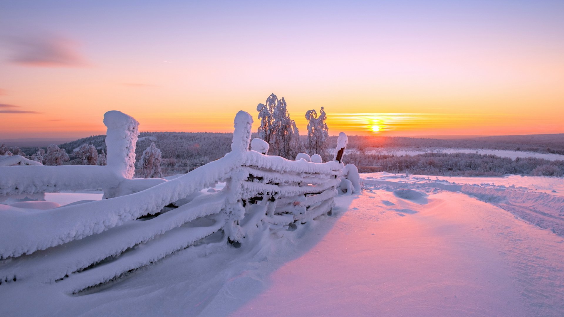 HD photography of a winter landscape at sunset, featuring snow-covered wooden fences and trees under a colorful sky, designed as a PC desktop wallpaper and background.
