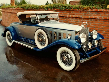 Vintage 1930 Cadillac V-16 convertible vehicle in glossy blue with whitewall tires, shown as HD PC desktop wallpaper background.