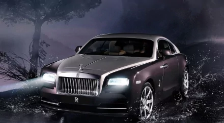 HD desktop wallpaper featuring a sleek Rolls-Royce Wraith with headlights on, set against a dark, moody backdrop with water splashing around.