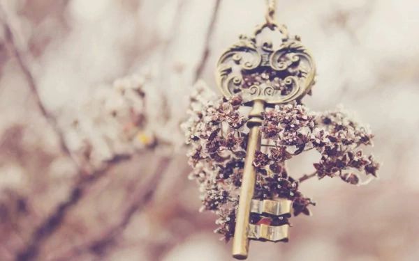 A vintage key hangs delicately from a branch adorned with soft pink blossoms, creating a serene and whimsical atmosphere for an HD PC desktop wallpaper and background.