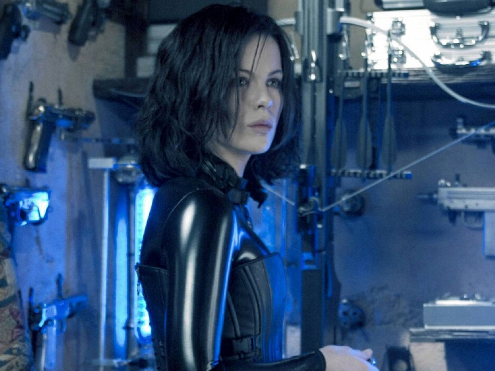 HD PC desktop wallpaper featuring a scene from the movie Underworld: Evolution with a character in a black leather outfit in a dimly lit industrial setting.