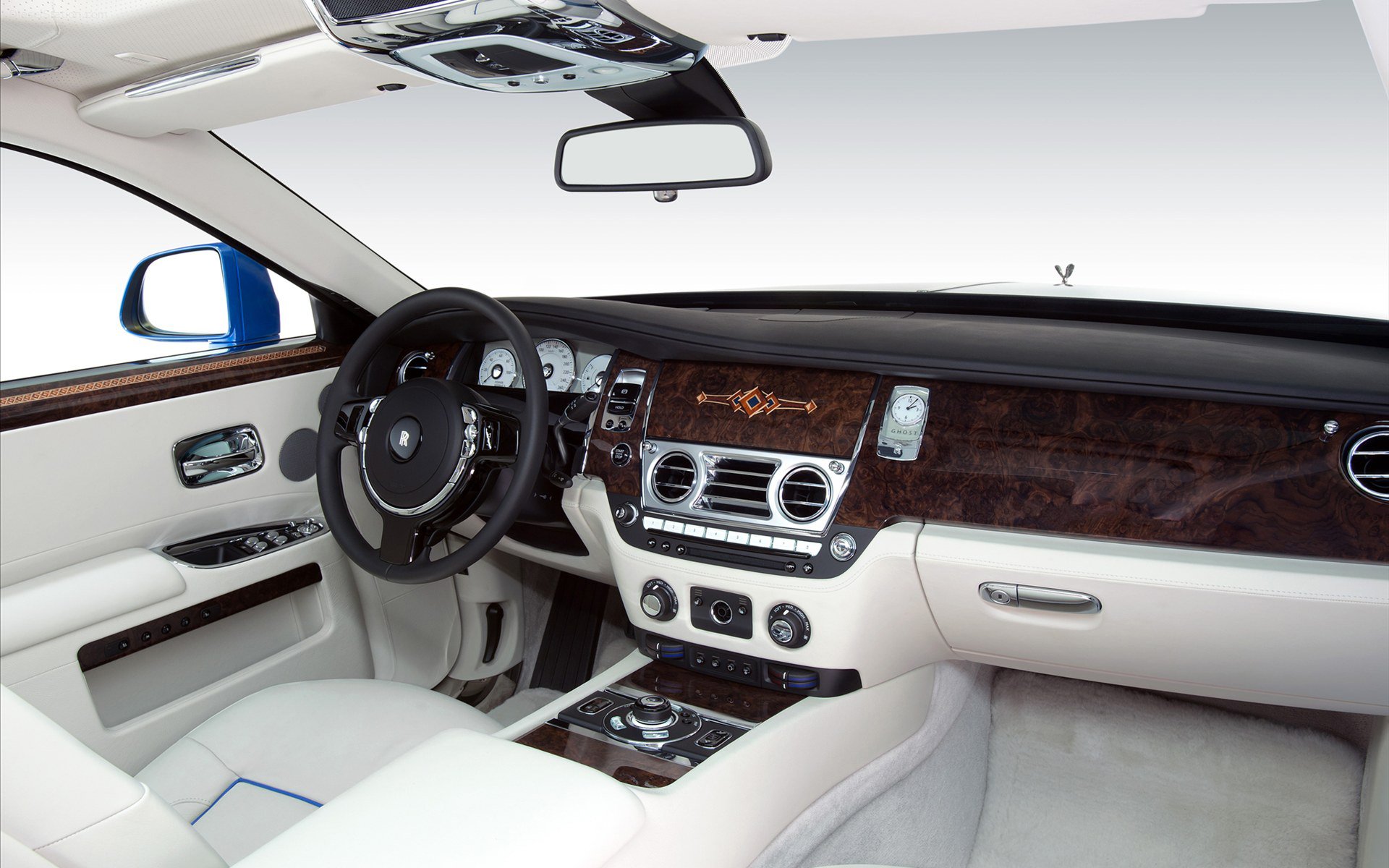 Luxurious interior view of a Rolls-Royce Ghost, showcasing elegant leather seating, polished wood accents, and advanced control features. Perfect HD desktop wallpaper for auto enthusiasts.
