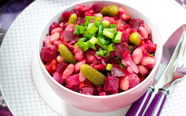 HD PC desktop wallpaper showing a vibrant bowl of salad with beans, pickles, beets, and chopped green onions on a white plate with cutlery.