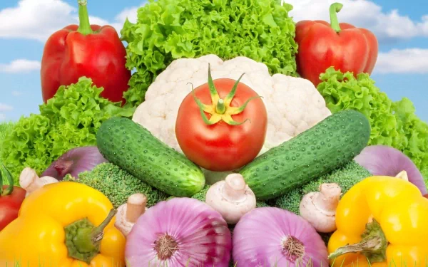 A vibrant display of fresh vegetables, including red peppers, lettuce, cucumbers, tomatoes, and more, against a bright sky. This HD wallpaper showcases a colorful array of produce.