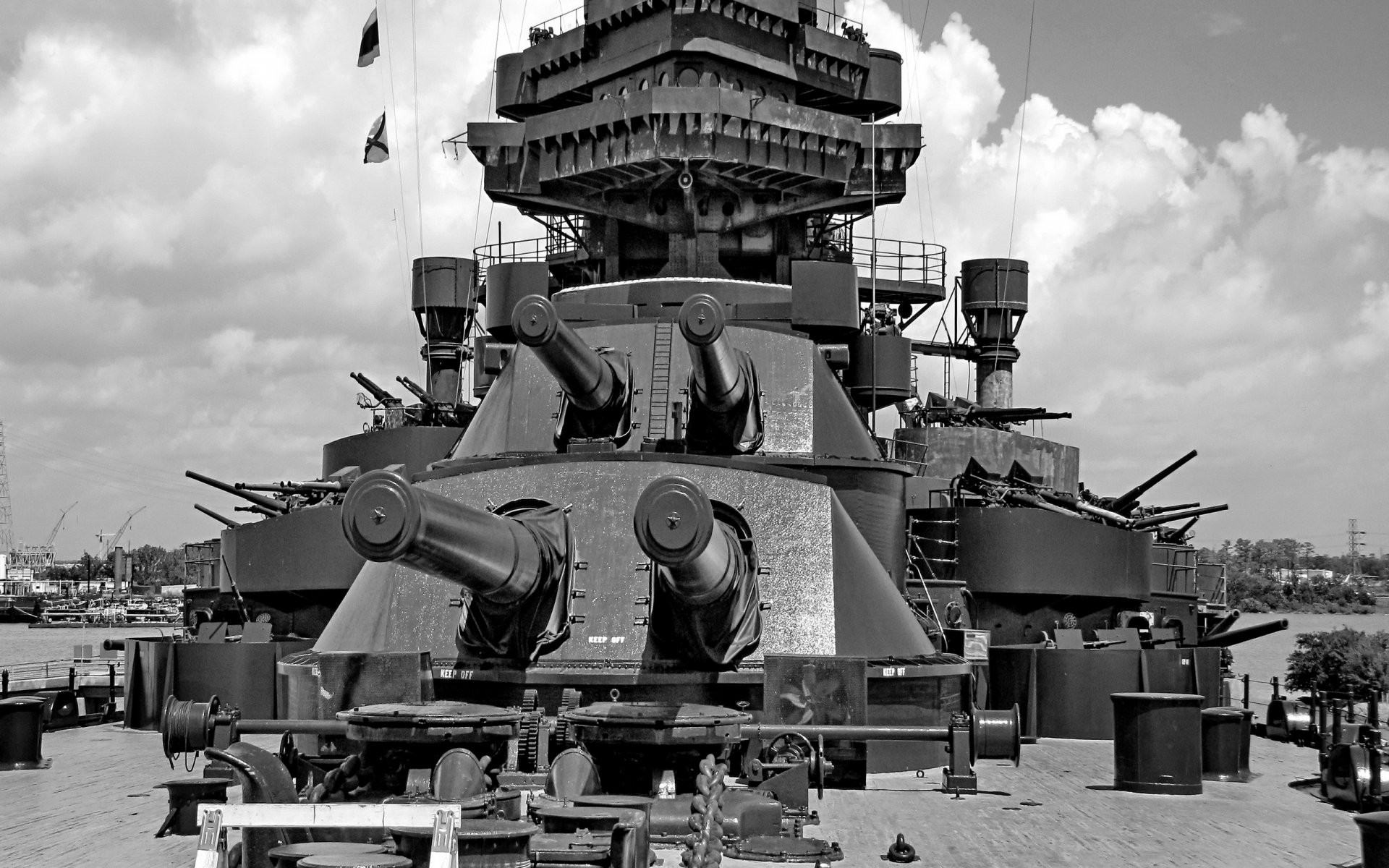 HD desktop wallpaper showing a detailed close-up of a military battleship's large turret guns under a cloudy sky.
