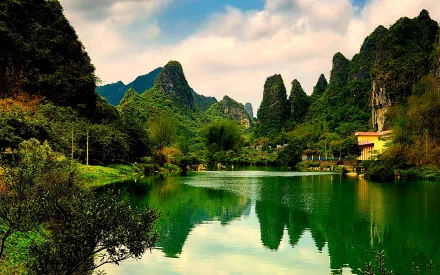 A tranquil scenic photograph showcasing lush green mountains reflected in a serene lake, providing an enchanting backdrop for a HD desktop wallpaper.