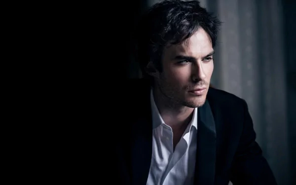HD desktop wallpaper featuring celebrity Ian Somerhalder, dressed in a suit and captured in a contemplative pose against a dark, softly lit background.