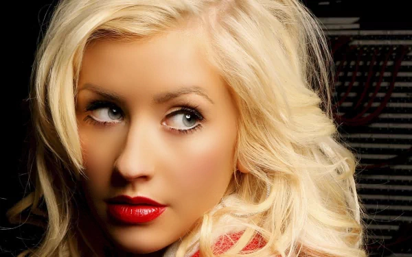 HD PC desktop wallpaper featuring a close-up of music artist Christina Aguilera with blonde hair and red lipstick against a dark background.