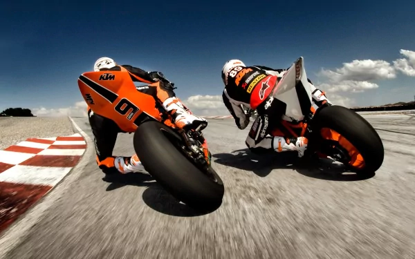 HD wallpaper featuring motorcycle racers leaning into a tight corner on a racetrack, capturing the intensity and speed of the sport.