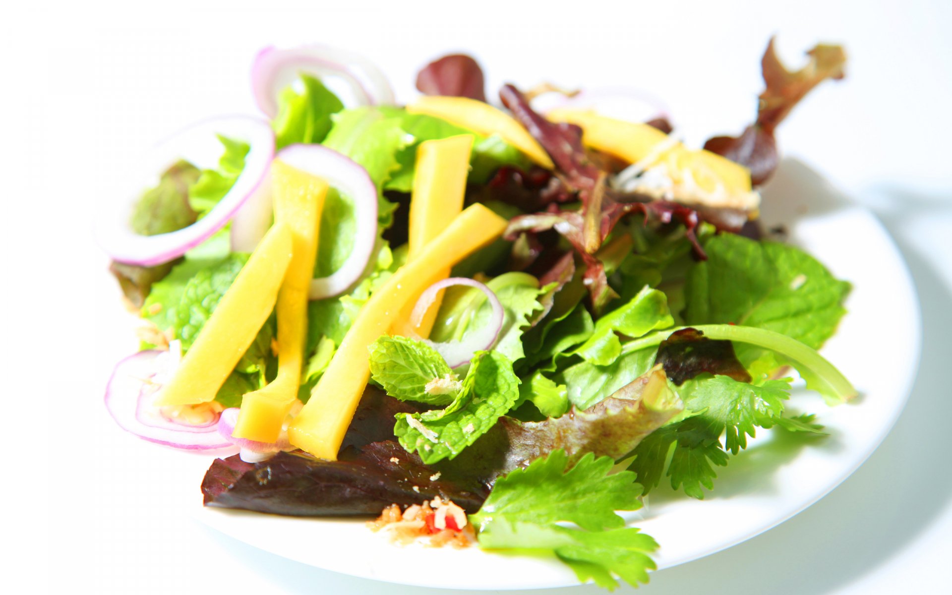 HD PC desktop wallpaper featuring a fresh, colorful salad with mixed greens, onion slices, and cheese on a white plate against a bright background.