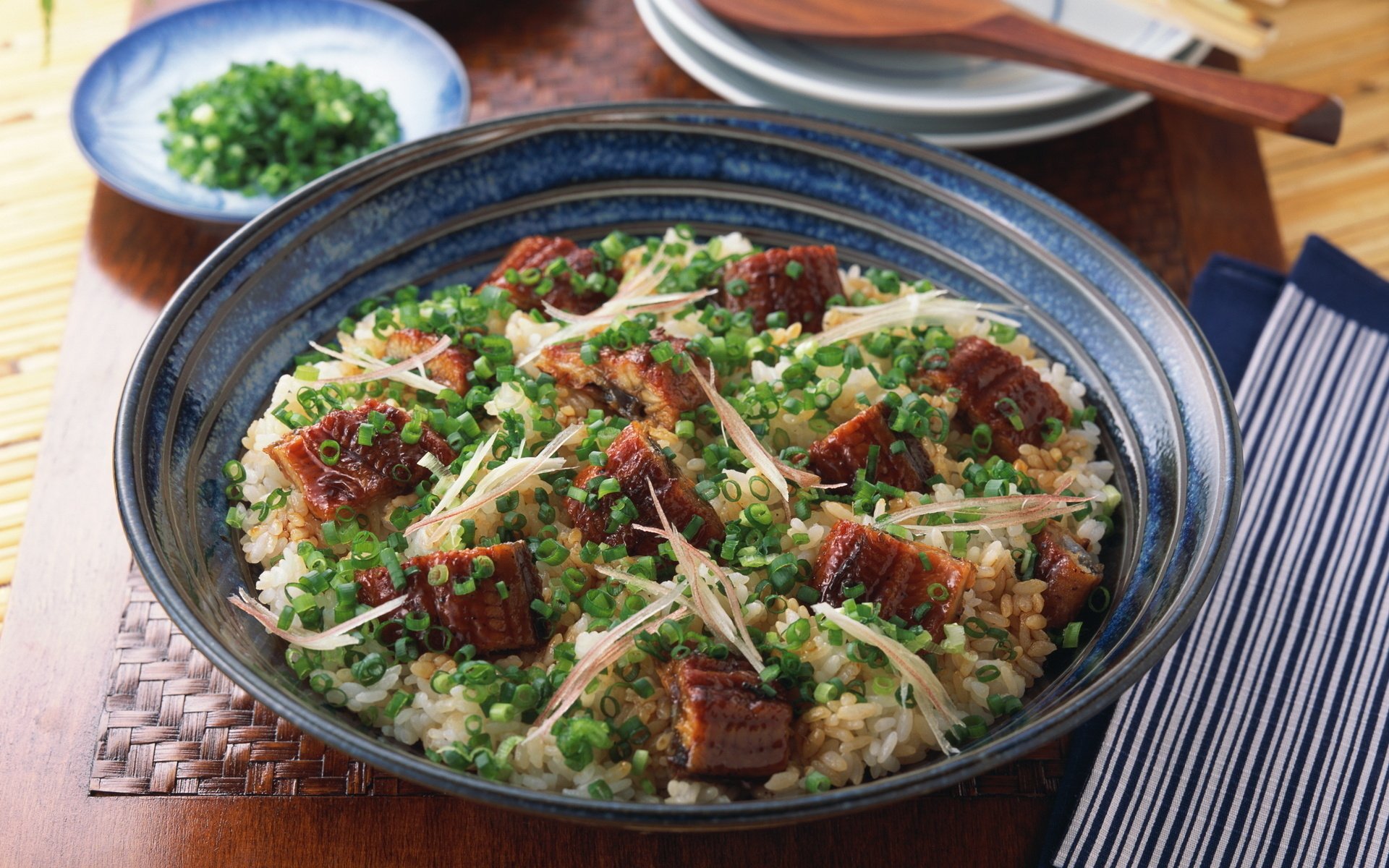 A vibrant dish featuring cooked fish atop a bed of rice, garnished with green onions and sliced ginger, set against a rustic wooden table—an enticing food-themed HD desktop wallpaper.