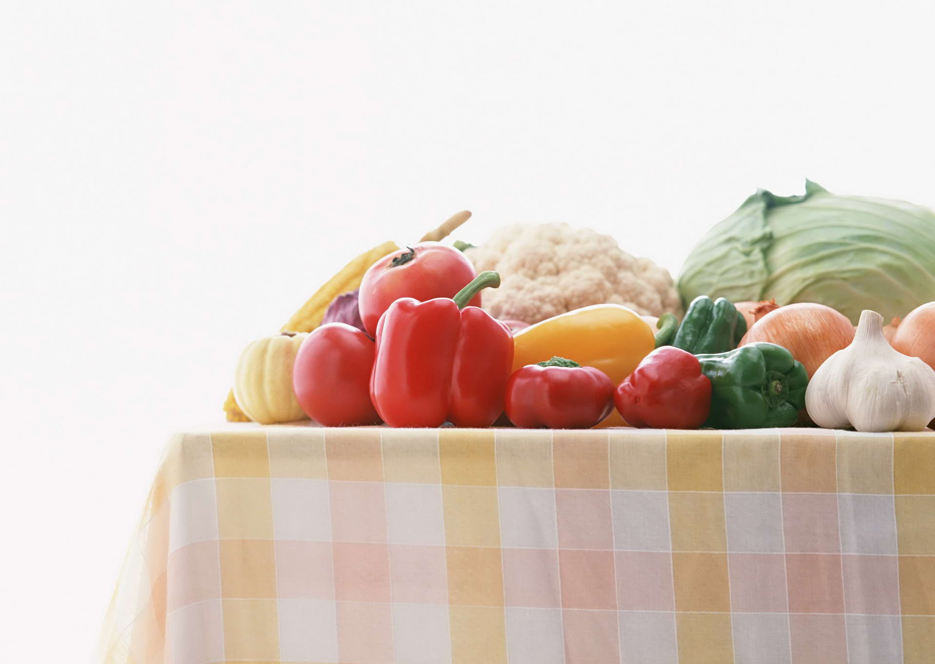 HD PC desktop wallpaper featuring a colorful assortment of fresh vegetables displayed on a checkered tablecloth against a white background.