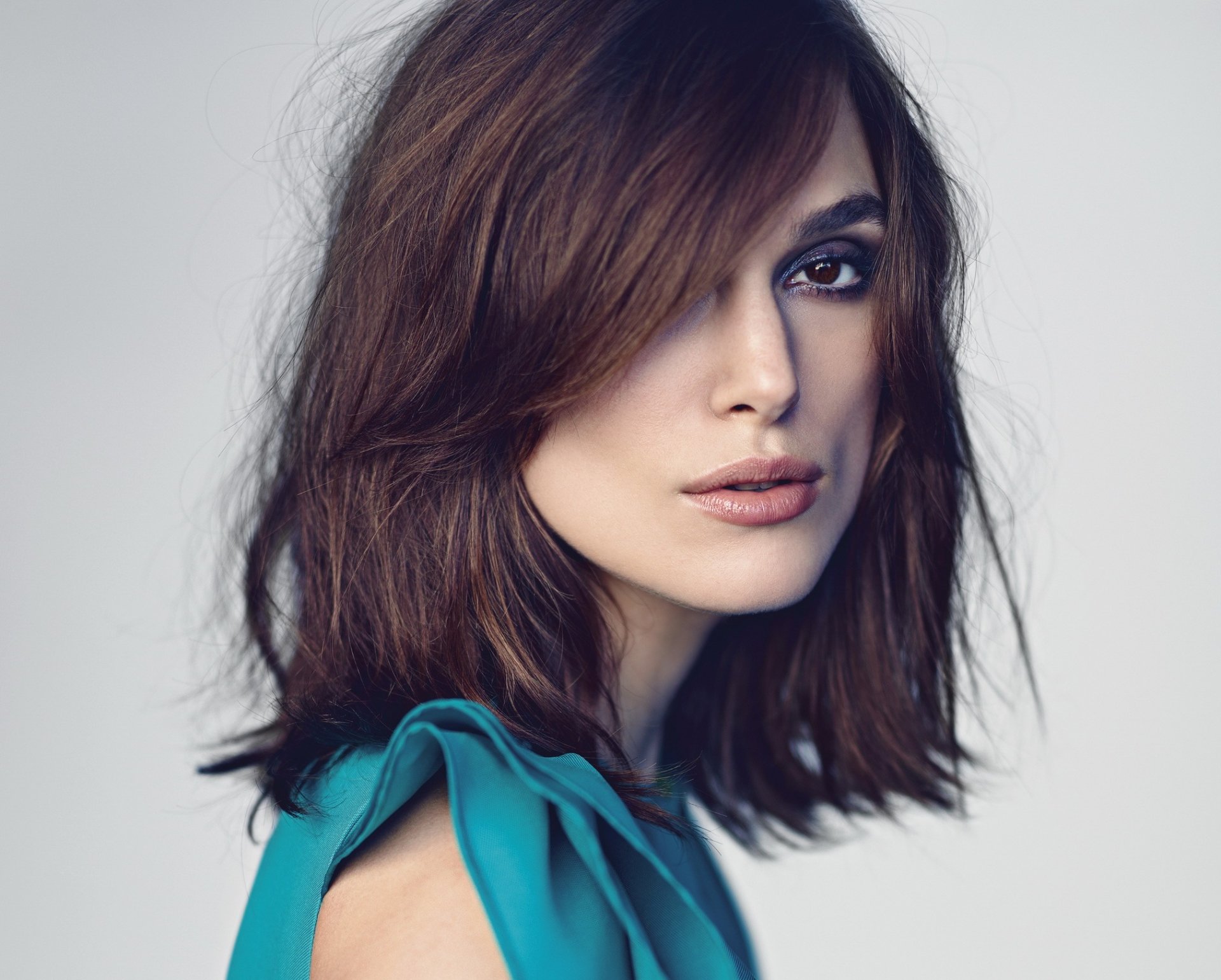 A striking HD wallpaper featuring English actress Keira Knightley, showcasing her brown eyes and brunette hair, captured in a captivating pose.