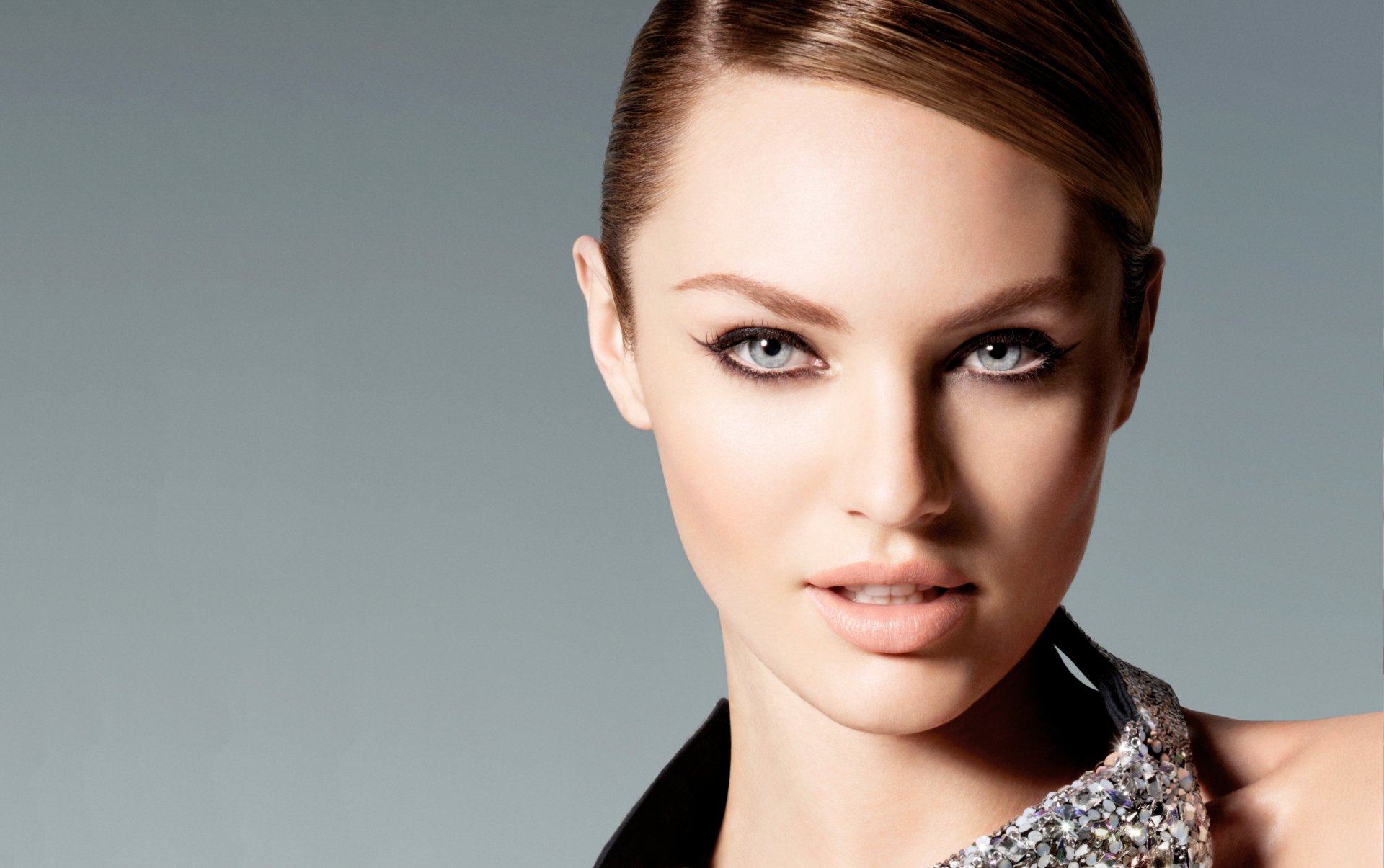 A stunning HD wallpaper featuring a close-up of a woman with striking features and captivating eyes, highlighted by an elegant outfit and contemporary background.