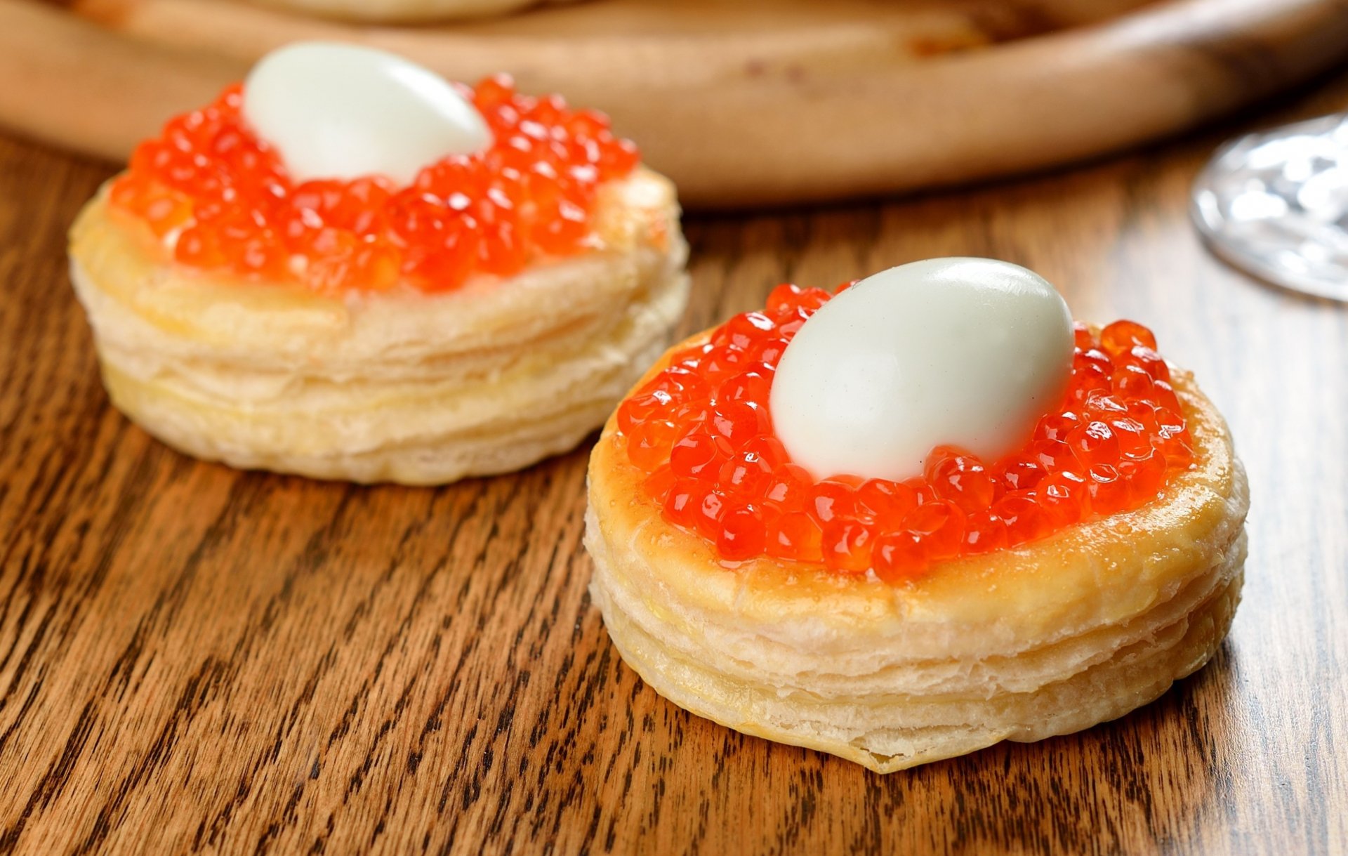 HD desktop wallpaper featuring close-up of appetizing vol-au-vents topped with vibrant orange caviar and a smooth white garnish on a wooden surface.