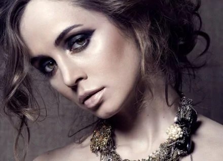 HD PC desktop wallpaper featuring a close-up portrait of celebrity Eliza Dushku with dramatic makeup and styled hair against a muted background.