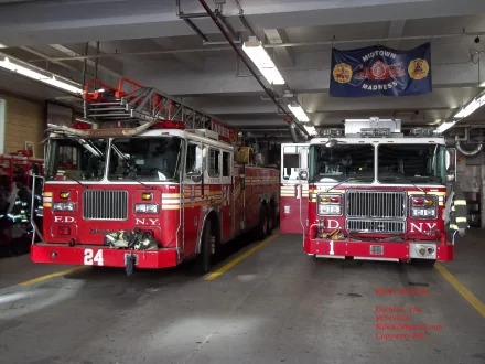 Two red Seagrave fire trucks parked inside a fire station garage, captured in a detailed 4K Ultra HD desktop wallpaper image.