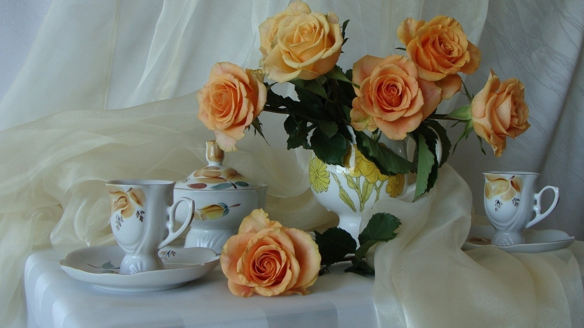 HD still life photography of peach roses arranged in a vase with matching porcelain tea set, styled delicately against a soft fabric backdrop, designed as a PC desktop wallpaper.