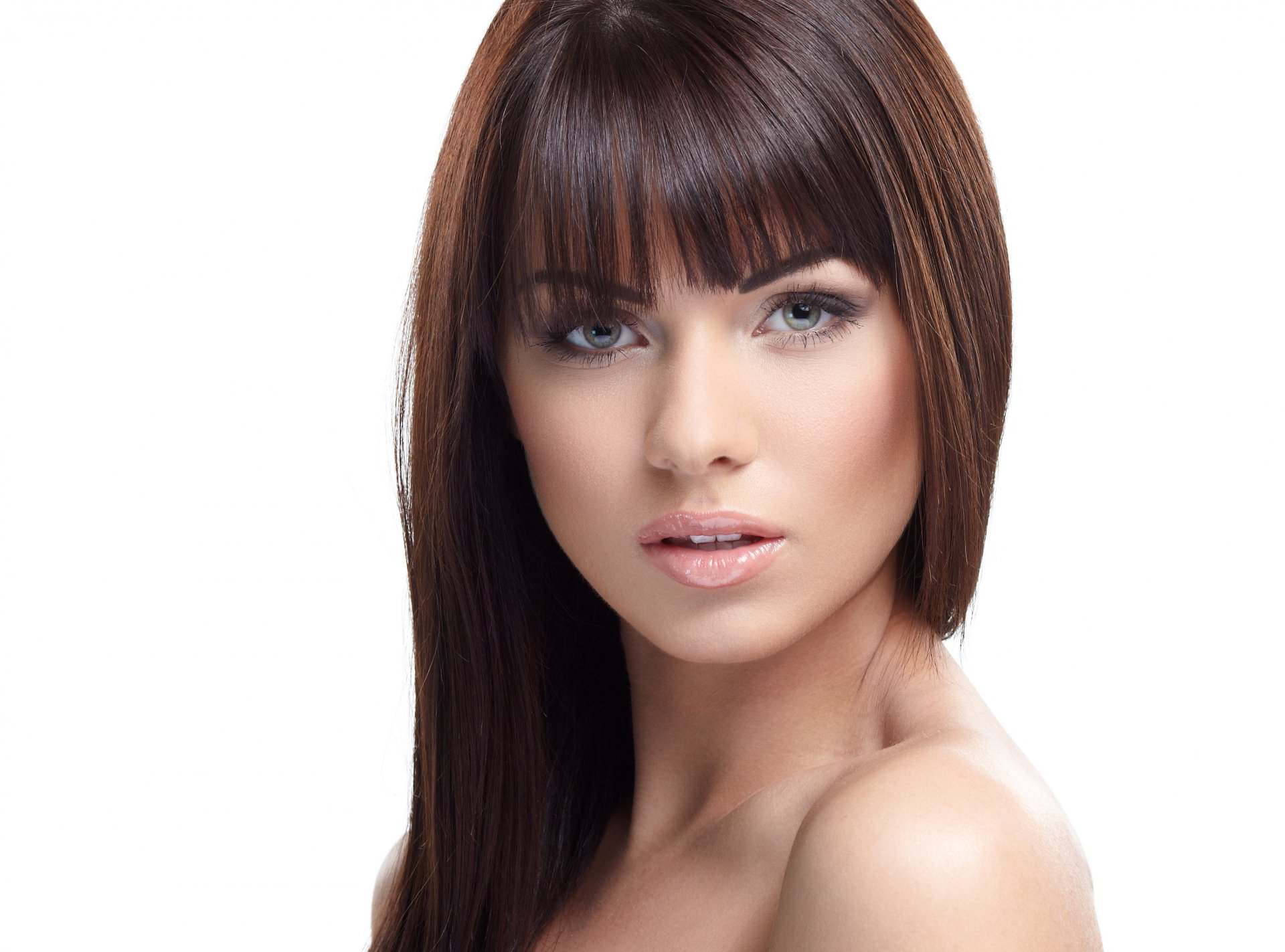 A stunning woman with long, dark brown hair and striking blue eyes poses confidently, creating an engaging HD desktop wallpaper and background.