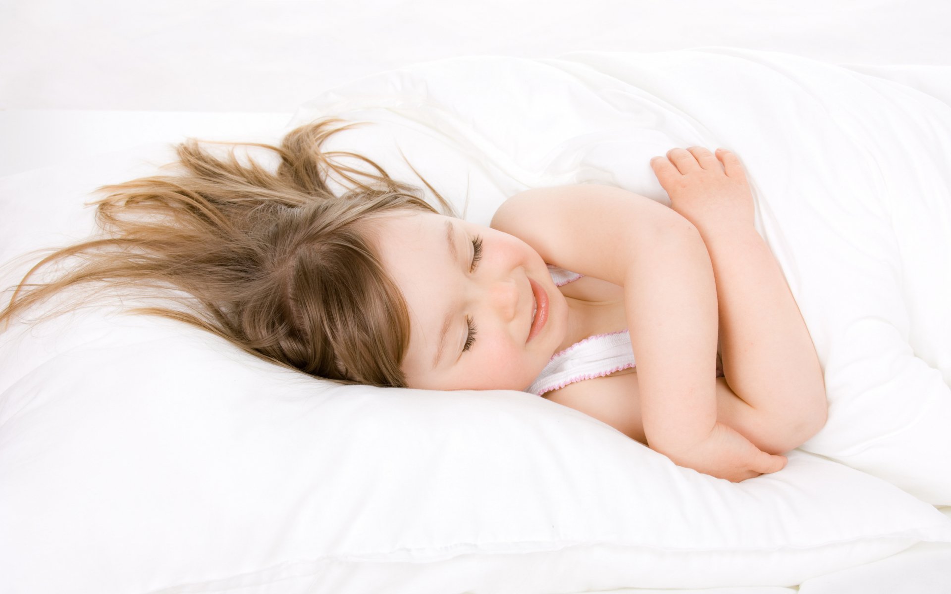 HD desktop wallpaper featuring a peaceful child sleeping on a white bed, captured in soft natural light through photography.
