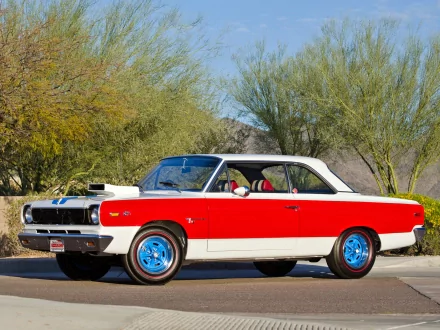 1969 Hurst AMC SC/Rambler coupe in red and white with blue rims, parked on a sunlit desert road — HD PC desktop wallpaper/background.