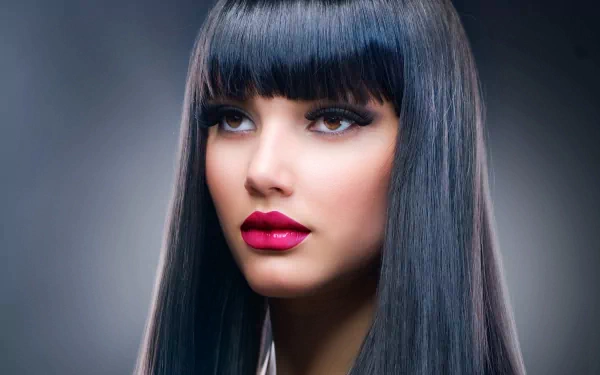 A stunning HD desktop wallpaper featuring a woman's face, showcasing sleek black hair and striking makeup, capturing a captivating and artistic expression.