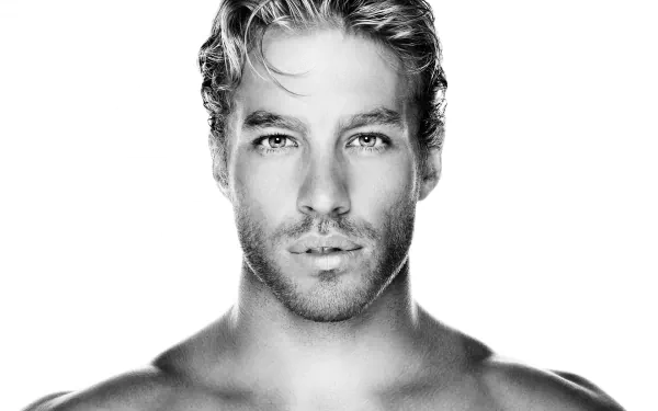 Black and white HD desktop wallpaper featuring a beautiful man with stylishly tousled hair and an intense gaze, providing a striking and elegant background.