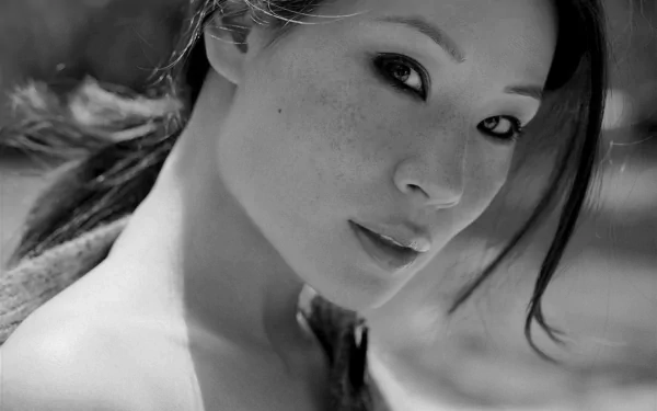 Black-and-white HD desktop wallpaper featuring Lucy Liu, capturing her expressive gaze and individual style in a striking portrait.