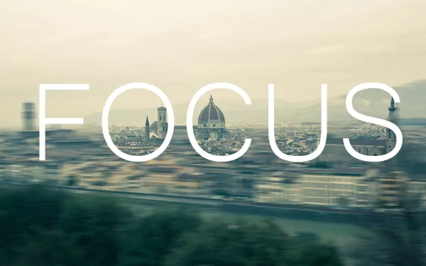 Minimalist artistic HD PC desktop wallpaper featuring a blurred cityscape of Florence with the word FOCUS boldly overlaid.