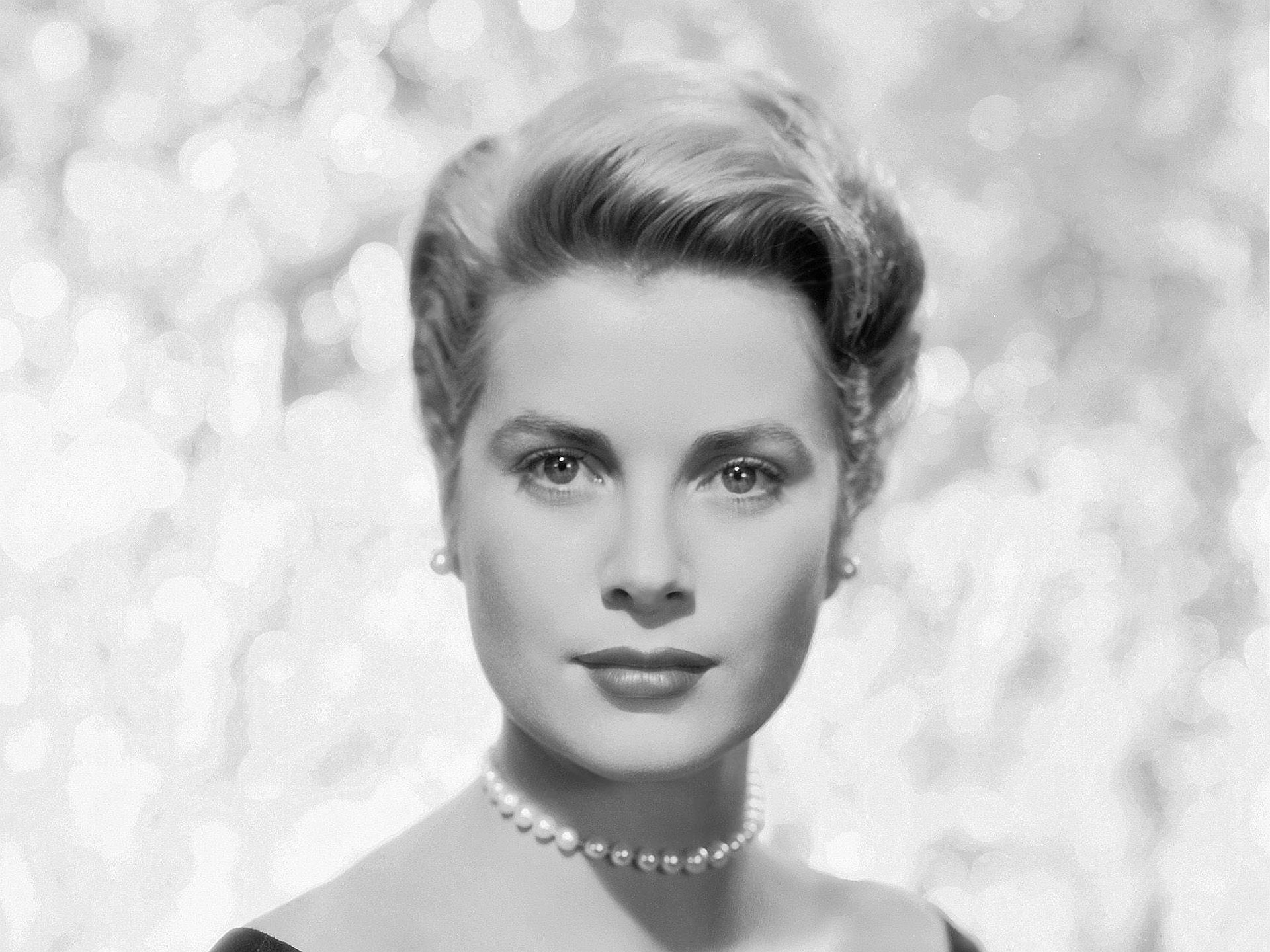 HD PC desktop wallpaper: black-and-white portrait of an elegant classic Hollywood celebrity wearing a pearl necklace against a soft, sparkling bokeh background.