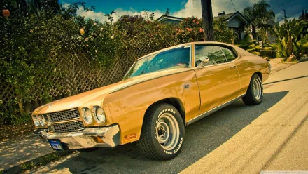 A striking yellow Chevrolet Chevelle SS parked on a sunny street, showcasing its classic muscle car design and gleaming features against a vibrant background.