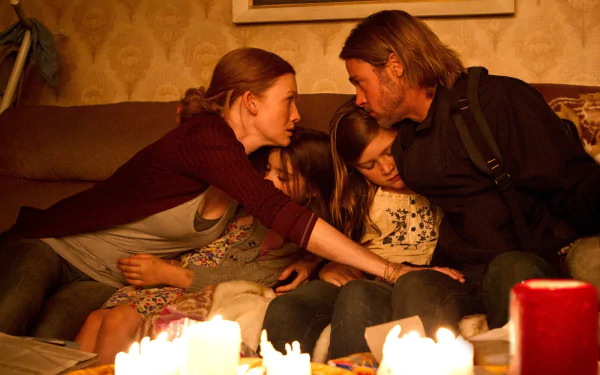 HD PC desktop wallpaper from the movie World War Z showing a family huddled closely together on a couch, illuminated by candlelight.