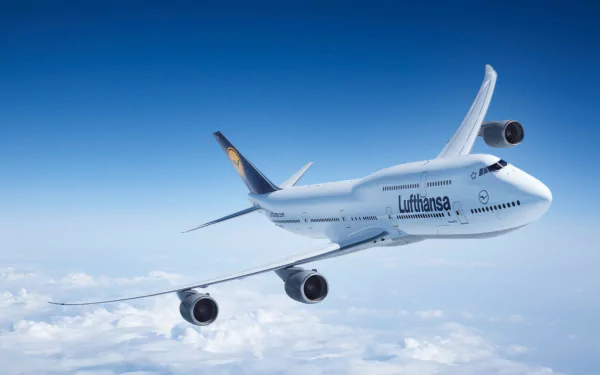 A Boeing 747-8 flying through a clear blue sky, showcasing its sleek design and powerful engines, serves as a stunning HD desktop wallpaper and background.