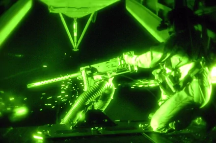 A high-definition desktop wallpaper featuring a soldier operating a machine gun, captured in green night vision, showcasing the intensity of a tactical situation.
