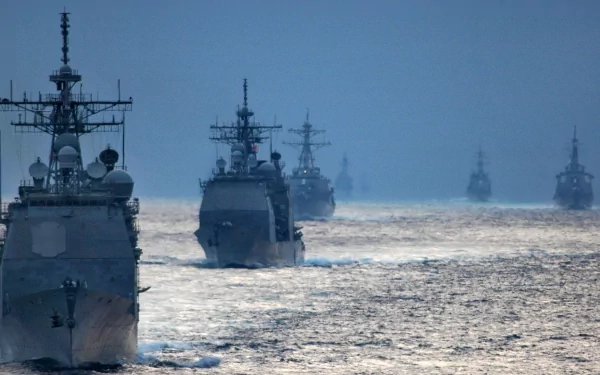 HD desktop wallpaper showing a military naval fleet sailing in formation on calm waters under a clear sky.