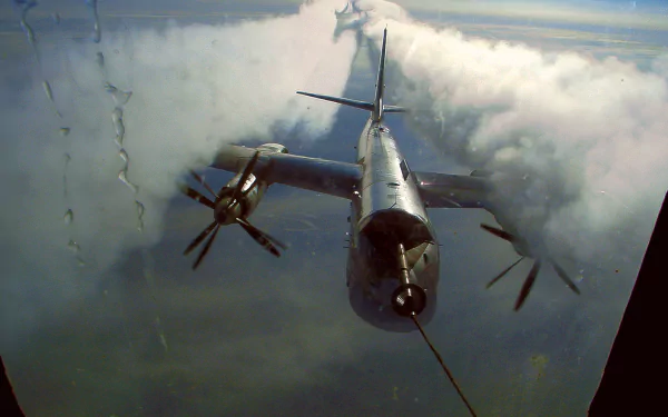 HD desktop wallpaper of a military Tupolev Tu-95 bomber flying above the clouds, showcasing its distinctive turboprop engines and sleek design.
