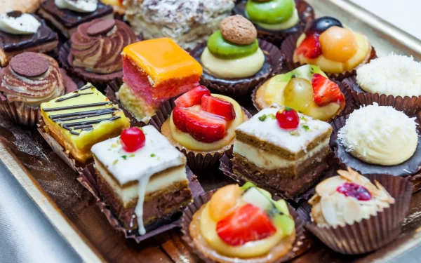 A colorful assortment of cupcakes and desserts beautifully arranged on a tray, creating a delightful and vibrant food-themed HD desktop wallpaper.