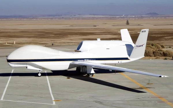 HD desktop wallpaper featuring a Northrop Grumman RQ-4 Global Hawk military drone on a desert airstrip.