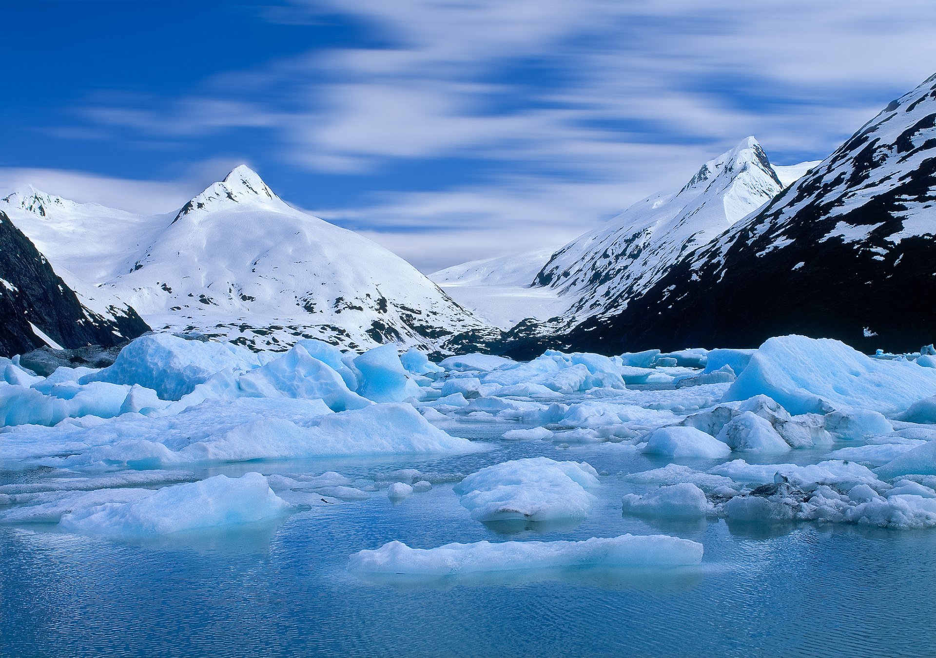 HD PC desktop wallpaper showcasing a serene nature scene with snow-covered mountains and floating icebergs under a vibrant blue sky.