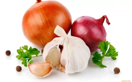 A vibrant HD desktop wallpaper featuring an array of fresh vegetables, including red and brown onions, garlic, and parsley, artfully arranged against a clean background.