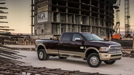 HD PC desktop wallpaper/background of a vehicle: a Dodge Ram 3500 crew cab pickup parked among steel beams in front of an unfinished construction building.