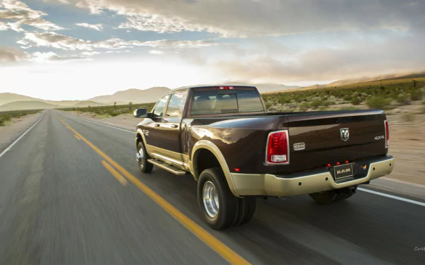 HD PC desktop wallpaper/background of a vehicle — a brown Dodge Ram 3500 pickup driving down an empty highway at sunset.