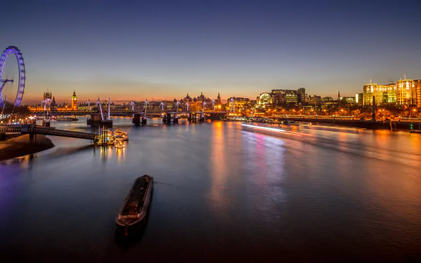 HD desktop wallpaper of a sunset view over the River Thames in London, featuring the London Eye and city lights reflecting on the water.