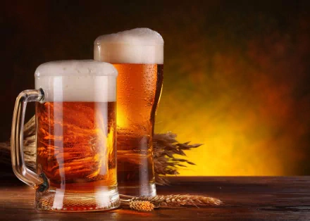 4K Ultra HD wallpaper featuring two frosty mugs of amber beer with foam, set against a warm, glowing background with barley and hops.