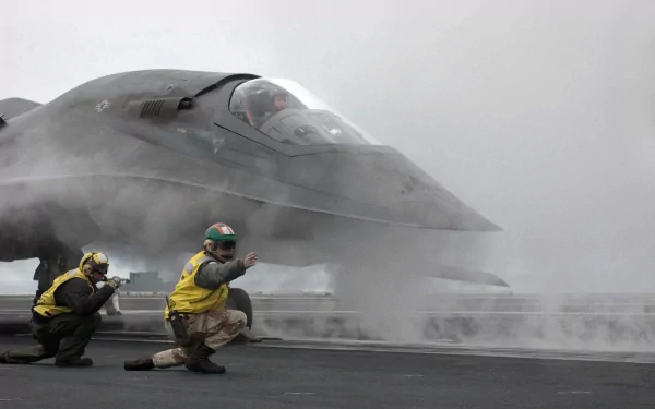 HD PC desktop wallpaper from the movie Stealth featuring a stealth fighter jet on an aircraft carrier deck with crew members in action.