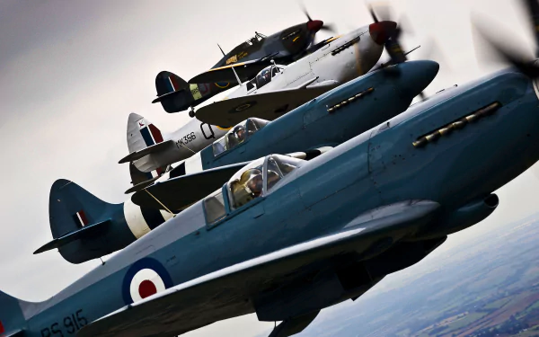 3 military Hawker Hurricane fighter planes fly in formation, captured in sharp detail against a cloudy sky in this 4K Ultra HD desktop wallpaper.