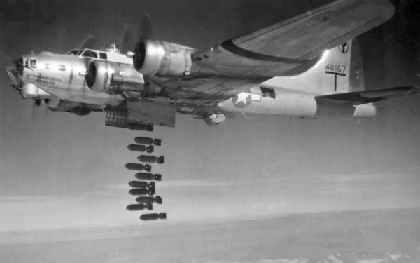 Black and white HD desktop wallpaper featuring a Boeing B-17 Flying Fortress dropping bombs during a military mission.