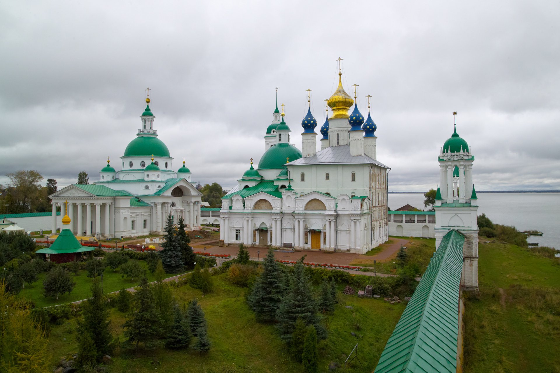 A majestic church complex with vibrant green and gold domes, set against a cloudy sky, makes for an inspiring HD desktop wallpaper that captures a serene religious atmosphere.