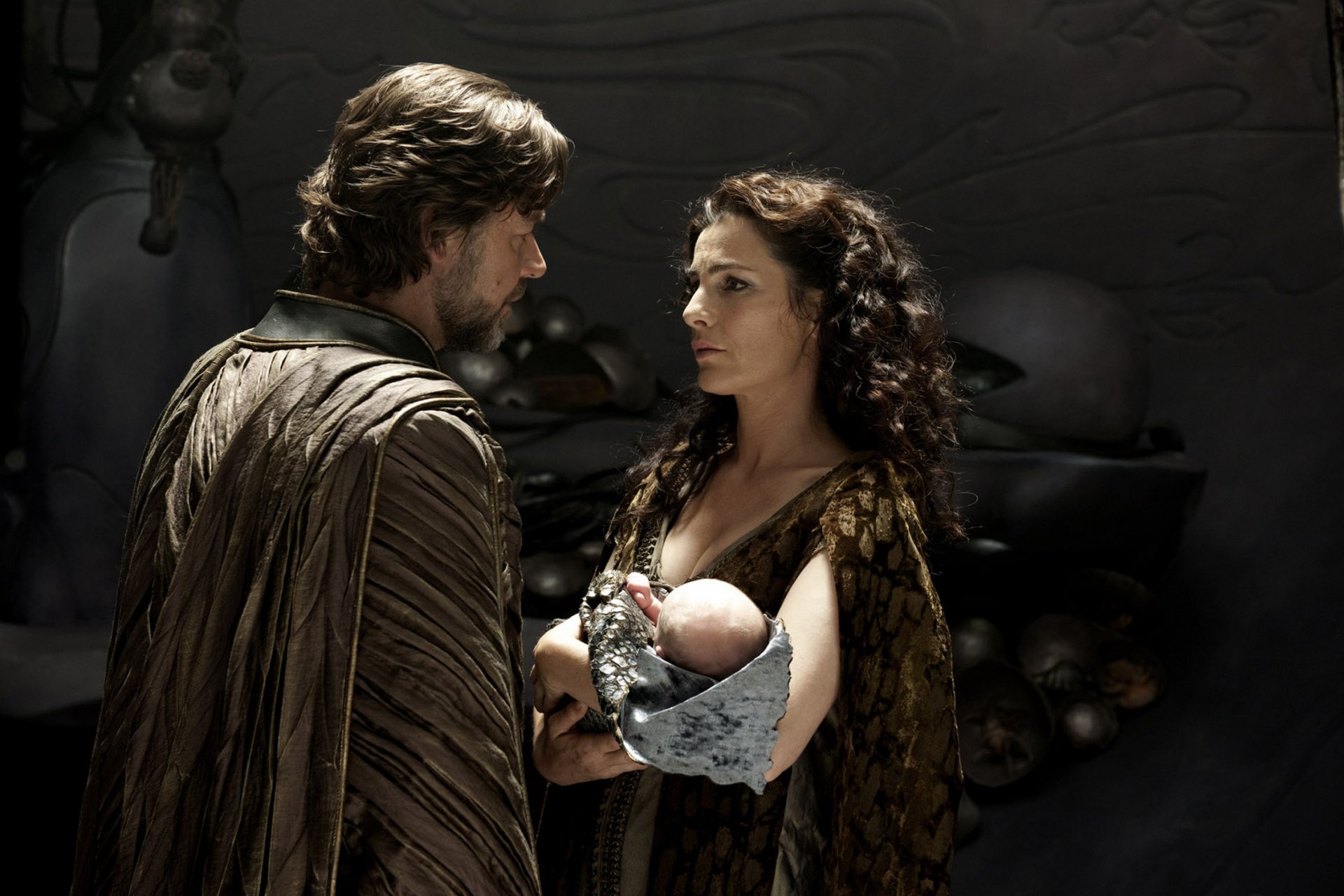 HD desktop wallpaper: Jor-El and Lara Lor‑Van on Krypton, Lara cradling baby Kal‑El as the parents share a solemn, protective moment from the Man of Steel movie.